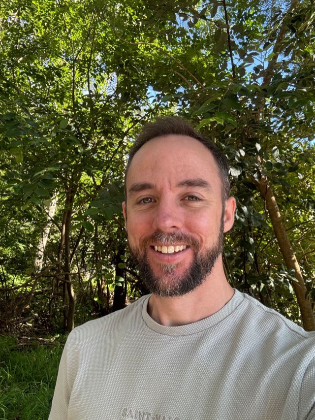 Matthew Hardy, counsellor, smiling outdoors among trees